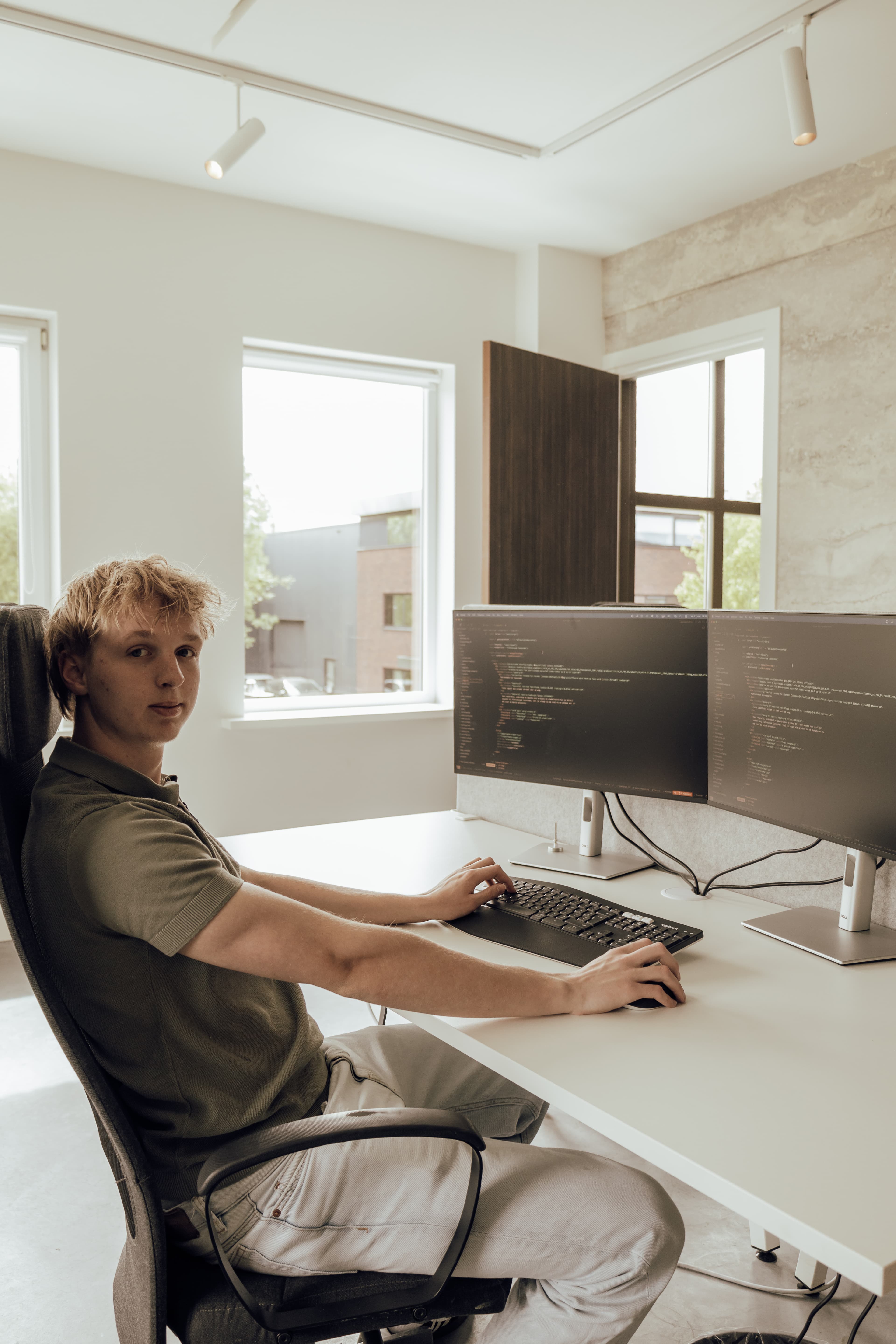 Ontwikkelaar aan een bureau met twee schermen